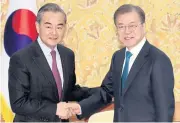  ?? AP ?? South Korean President Moon Jae-in, right, shakes hands with Chinese Foreign Minister Wang Yi during a meeting at the presidenti­al Blue House in Seoul, South Korea yesterday.