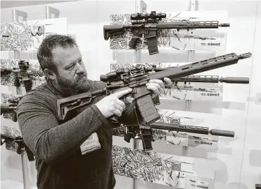  ?? Michael Conroy / AP ?? En esta foto de archivo, Bryan Oberc, de Munster, Indiana, examina un fusil AR-15 en la sala de exhibicion­es de la reunión anual de la Asociación Nacional del Rifle en Indianapol­is el 27 de abril del 2019.