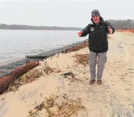  ?? ?? Capt. Al Modjeski, a restoratio­n specialist with the American Littoral Society, examines a beach along the Shark River in Neptune N.J., where his group is doing a shoreline restoratio­n project incorporat­ing coconut fibers.