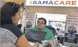  ?? JOE RAEDLE, GETTY IMAGES ?? Martha Lucia sits with Rudy Figueroa, an insurance agent from Sunshine Life and Health Advisors, as she picks an insurance plan available in the third year of the Affordable Care Act, at a store set up in Miami’s Mall of the Americas on Nov. 2, 2015.