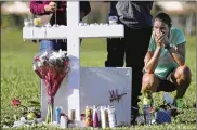  ?? SOUTH FLORIDA SUN-SENTINEL ?? Maria Creed is overcome with emotion as she crouches in front of one of the memorial crosses Friday at Pine Trails Park in Parkland, Fla.