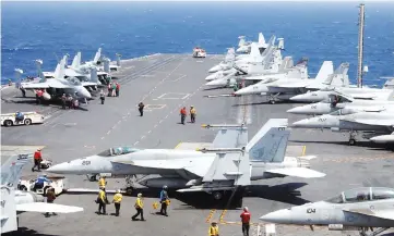  ??  ?? US Navy personnel prepare to launch an F18 fighter jet on the deck of USS Carl Vinson during a FONOPS (Freedom of Navigation Operation Patrol) in South China Sea. — Reuters photo