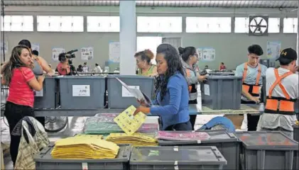  ?? / J. O. (AFP) ?? Empleadas de la corte electoral preparan urnas y papeletas el jueves en Ciudad de Guatemala.