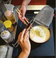  ?? Mark Mulligan / Houston Chronicle ?? Line cooks prepare ramen, with Sun Noodle ingredient­s, at Ramen Tatsu-ya in Montrose.
