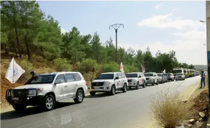  ?? Reuters ?? A convoy carrying food and humanitari­an supplies waits to deliver aid to Syrian besieged towns, near Damascus. —