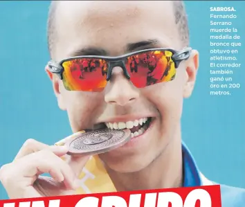  ??  ?? SABROSA. Fernando Serrano muerde la medalla de bronce que obtuvo en atletismo. El corredor también ganó un oro en 200 metros.