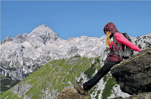  ?? 123RF ?? A hiker resting in front of Mt Triglav in the Julian Alps.