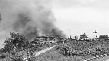  ??  ?? The fire spreading fiercely across the longhouse.