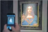 ?? AFP ?? A visitor takes a photo of the Leonardo da Vinci painting Salvator Mundi at Christie's New York Auction House.
