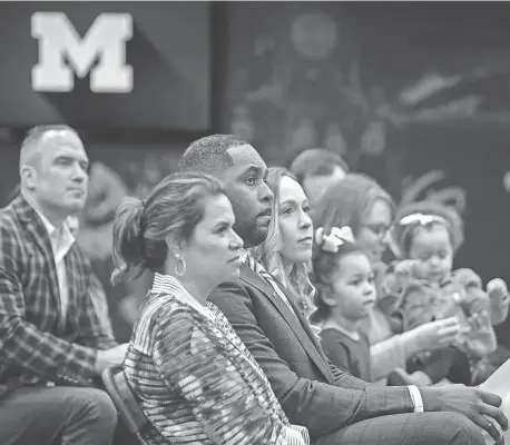  ?? DAVID RODRIGUEZ MUNOZ/DETROIT FREE PRESS ?? Sherrone Moore, Michigan’s new head coach, sits next to friends and family during a press conference inside the Junge Family Champions Center in Ann Arbor on January 27.