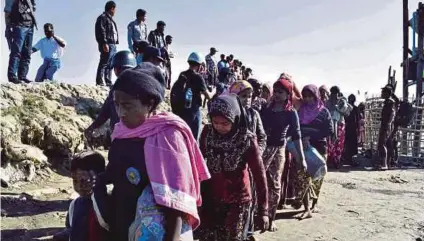  ?? [FOTO AFP] ?? Gambar fail menunjukka­n pegawai tentera laut Myanmar mengiringi pelarian Rohingya yang ditangkap untuk dibawa pulang ke kem di Sittwe, Rakhine.