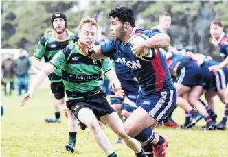  ?? PHOTO: DEBBIE FAHEY ?? Ball in hand . . . Woodlands midfield back Ray Nu’u, who is turning out for Green Island in the Dunedin competitio­n this year, looks to go past Jeremy Boyle, of Marist in a club game last year.