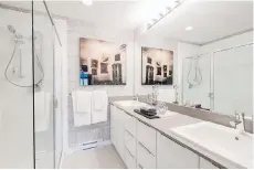  ??  ?? Bathrooms have full-height vanity mirrors with engineered stone countertop­s and showers with glass doors and bench seating.