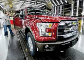  ?? AP/ CHARLIE RIEDEL ?? A worker inspects a new aluminum- alloy body Ford F- 150 at the company’s Kansas City Assembly Plant in Claycomo, Mo., in March. Ford’s U. S. sales jumped 5 percent in August on sales of the new F- 150.