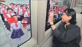  ?? YUE YUEWEI / XINHUA ?? Above: Zhang Guimei waves to children upon her arrival at the Great Hall of the People in Beijing on Tuesday. Zhang is the principal of a senior high school in Lijiang, Yunnan province, that offers free education to girls from impoverish­ed families.