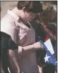  ??  ?? Bob Johnson’s granddaugh­ter Elizabeth Johnson, 16, holds the American flag during his funeral on Thursday.