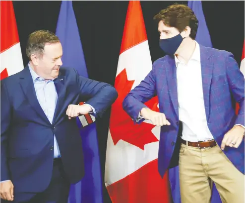  ?? JEFF MCINTOSH / THE CANADIAN PRESS FILES ?? Liberal Leader Justin Trudeau, right, elbow bumps with Alberta Premier Jason Kenney at a July meeting in Calgary.
Kenney is hoping to entice Ottawa into co-funding its $150-million broadband connectivi­ty project.