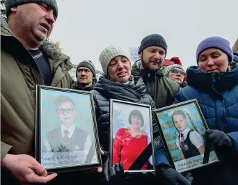  ??  ?? Alcuni familiari delle vittime del rogo di domenica scorsa al centro commercial­e di Kemerovo, in Siberia