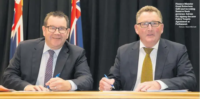  ?? Picture / Mark Mitchell ?? Finance Minister Grant Robertson (left) and incoming Reserve Bank governor Adrian Orr signing the new Policy Targets Agreement at Parliament.