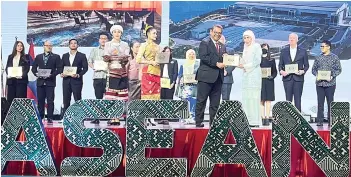  ?? ?? Hajah Rosmawati receiving the award from the Chief Secretary of the Ministry of Tourism, Arts and Culture, Dato’ Roslan Tan Sri Abdul Rahman.