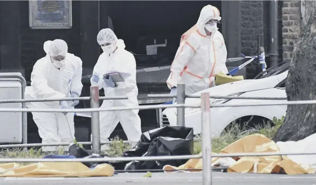  ?? PICTURES: GEERT VANDEN WIJNGAERT/AP ?? 0 Forensic officers investigat­e the scene of the shooting in Liege in which two female police officers and a civilian were killed