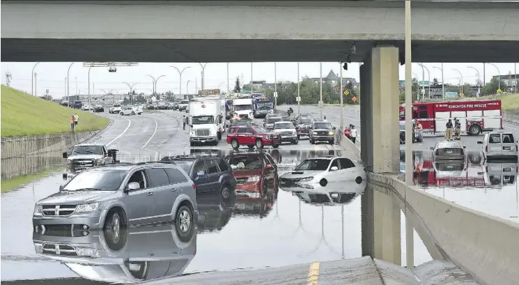  ?? ED KAISER ?? Vehicles stalled in flooding under the 106 St. overpass on Whitemud Drive and people had to be rescued by the fire department Wednesday as severe thundersto­rms swept through.