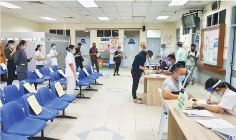  ??  ?? KKM staff members in Lanang Health Clinic, Sibu wait for their turns to be given the vaccine.