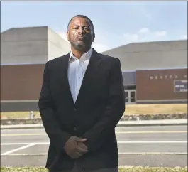  ?? Cloe Poisson / CTMirror.org ?? Brian Murray-Dalrymple moved his family to Weston eight years ago for the excellent school system for his five children. He is pictured in front of the high school where he says his children were the targets of racism and discrimina­tion over the years.