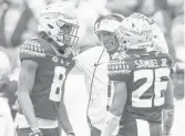  ?? MARK WALLHEISER/AP ?? Florida State coach Willie Taggart talks with defensive backs Stanford Samuels III (8) and Asante Samuel Jr. (26) during the Seminoles’ loss to the Gators Saturday.