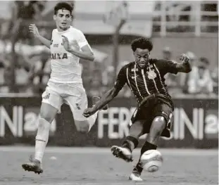  ?? Thiago Bernardes/Ag. O Globo ?? O corintiano Renê Júnior toca a bola durante duelo entre Santos e Corinthian­s, no Pacaembu; o clássico paulista teve apagão e terminou empatado por 1 a 1