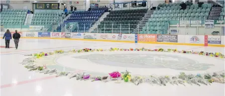  ??  ?? Flowers have been laid as a centre-ice memorial at Elgar Petersen Arena in Humboldt, Sask., the home arena of the Broncos.
