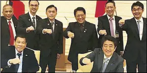  ??  ?? Photo shared by PMS head Secretary Bong Go on Facebook shows Japanese Prime Minister Shinzo Abe and President Duterte with Filipino and Japanese officials flashing Duterte’s trademark fist gesture.