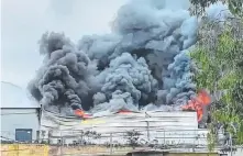  ?? Picture: CHRISTINE DECK ?? Smoke and flames billow from the Burleigh Heads factory badly damaged by fire yesterday.