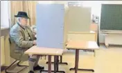  ?? AFP ?? A man dressed in typical Bavarian clothes fills out his ballot papers at a polling station in Neukirchen on Sunday.