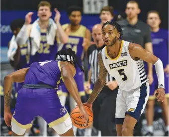  ?? STAFF PHOTO BY MATT HAMILTON ?? UTC senior guard Jamal Johnson brings the ball across midcourt as Western Carolina’s Tyler Harris defends during Wednesday’s SoCon game at McKenzie Arena.