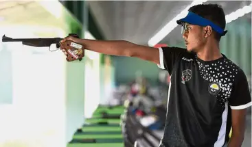  ??  ?? He aims high: Terengganu shooter Qamarul Naim Abu Aziz competing in the boys’ 50m pistol event.