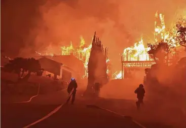  ?? Ryan Cullom / Ventura County Fire Department via AP ?? Firefighte­rs work to extinguish a blaze that grew wildly Tuesday in Ventura, Calif. Intense Santa Ana winds have whipped up explosive wildfires there, burning a psychiatri­c hospital and scores of other buildings.