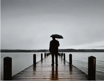  ?? Foto: Victoria Bonn Meuser, dpa ?? Wer bei Regenwette­r am Starnberge­r See steht, kann die melancholi­sche Stimmung durchaus genießen. Doch viele Menschen kennen auch tieftrauri­ge Gedanken, die sie über Wochen belasten. Dann ist Vorsicht geboten.