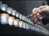  ?? WIN MCNAMEE / GETTY IMAGES ?? Survivors light candles during a commemorat­ion at the Holocaust Memorial Museum in Washington, D.C.