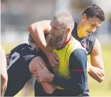  ??  ?? Max Gawn (centre) is tackled by teammates at training.