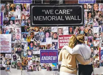  ?? SETH WENIG AP FILE ?? Theresa Sari (left) and her daughter Leila Ali look at a protest-memorial wall for nursing home residents who died from COVID-19, including Sari’s mother, Maria Sachse, in March in New York. A state Assembly committee investigat­ion found that former New York Gov. Andrew Cuomo’s administra­tion made a political decision to misreprese­nt how many nursing home residents died of COVID-19.