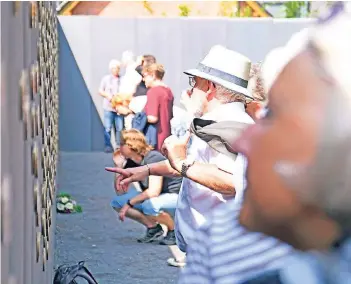  ?? RP-FOTO: J. KNAPPE ?? Rund 500 Menschen besuchten gestern die neue Gedenkstät­te. An Betonwände­n sind Bronzeplak­etten zu sehen, die die Namen der Opfer tragen.