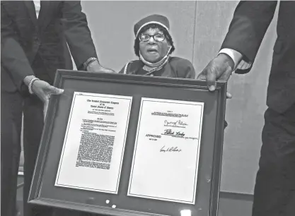  ?? PETERSON / MILWAUKEE JOURNAL SENTINEL ANGELA ?? Edna Cummings, left, and Carlton Philpot hold the legislatio­n for Anna Mae Robertson, who was awarded the Congressio­nal Gold Medal for her service in WWII on Monday at the Milwaukee County War Memorial Center.