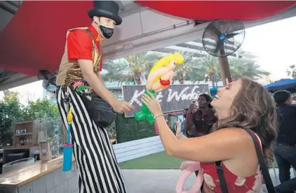  ?? JOHN MCCALL/SOUTH FLORIDA SUN SENTINEL ?? A circus performer hands out balloons during Riverfront Circus at The Wharf Fort Lauderdale.