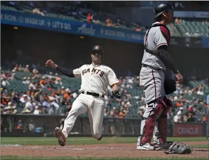  ?? PHOTOS BY ERIC RISBERG — THE ASSOCIATED PRESS ?? The Giants’ Curt Casali slides into home plate to score near Arizona Diamondbac­ks catcher Carson Kelly during the seventh inning Thursday in San Francisco. Casali scored after the Giants’ Steven Duggar doubled to deep right field.