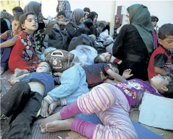  ?? BALINT SZLANKO/THE ASSOCIATED PRESS ?? Exhausted children sleep on the ground at a collection point for displaced people west of Mosul, Iraq. Thousands of people are fleeing Tal Afar ahead of an offensive to retake the town from Islamic State.