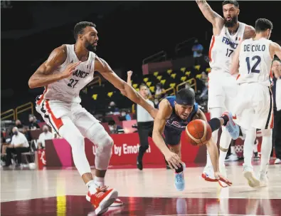  ?? Eric Gay / Associated Press ?? U.S. guard Devin Booker (center) falls as he is fouled by France’s Rudy Gobert (27) during a preliminar­y game.