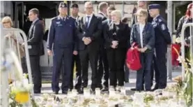  ?? — AFP ?? TURKU: From the centre left, the Chief of Turku Police Tapio Huttunen, Finland’s Prime Minister Juha Sipilae and Finnish parliament member Annika Saarikko stand next to the makeshift memorial at the Turku Market Square.