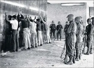  ?? AP FILE PHOTO ?? In this Oct. 3, 1968, photo, Mexican soldiers guard a group of young men rounded up after the night that came to be known as the “Tlatelolco massacre” in the Plaza of the Three Cultures area of Mexico City.