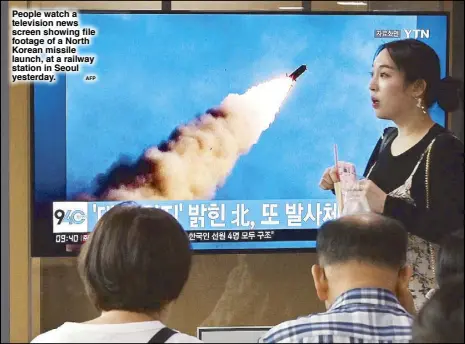  ?? AFP ?? People watch a television news screen showing file footage of a North Korean missile launch, at a railway station in Seoul yesterday.